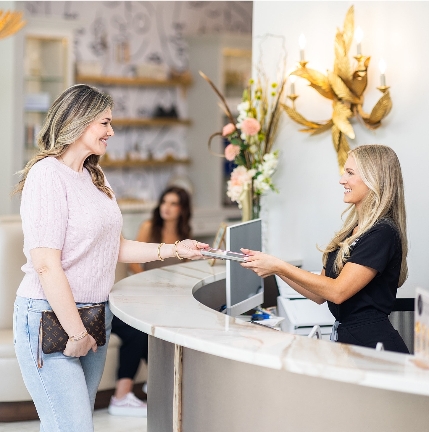 Happy customer checking in at reception desk.