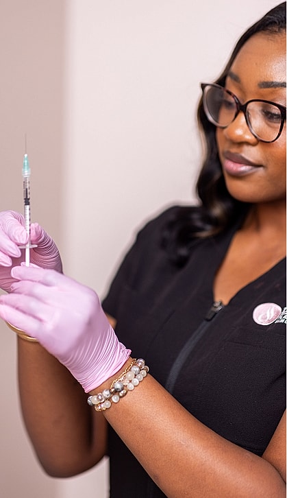 Health professional holding a syringe and smiling.