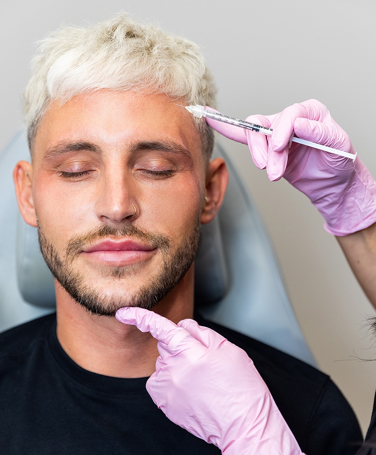 Man receiving cosmetic treatment in clinic setting.