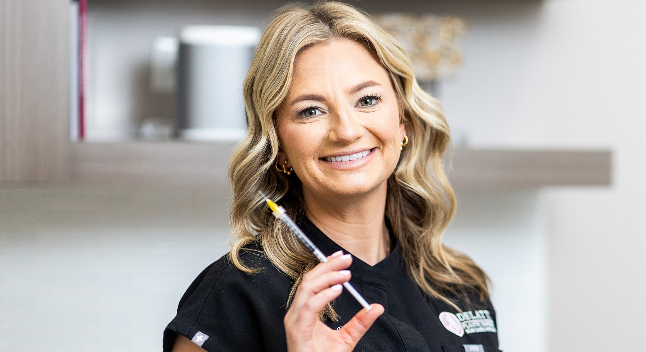 Smiling professional holding a syringe in clinic.