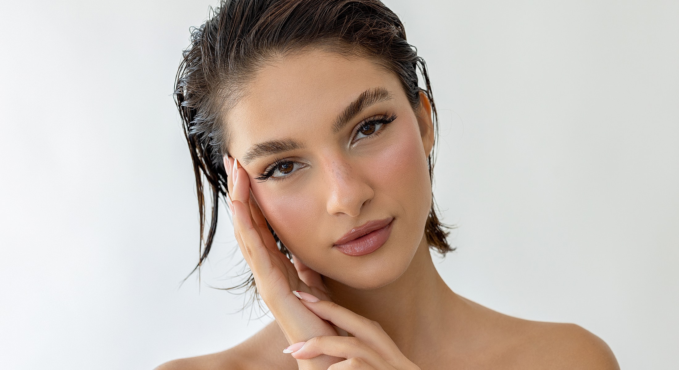 Person with wet hair posing against a neutral background.